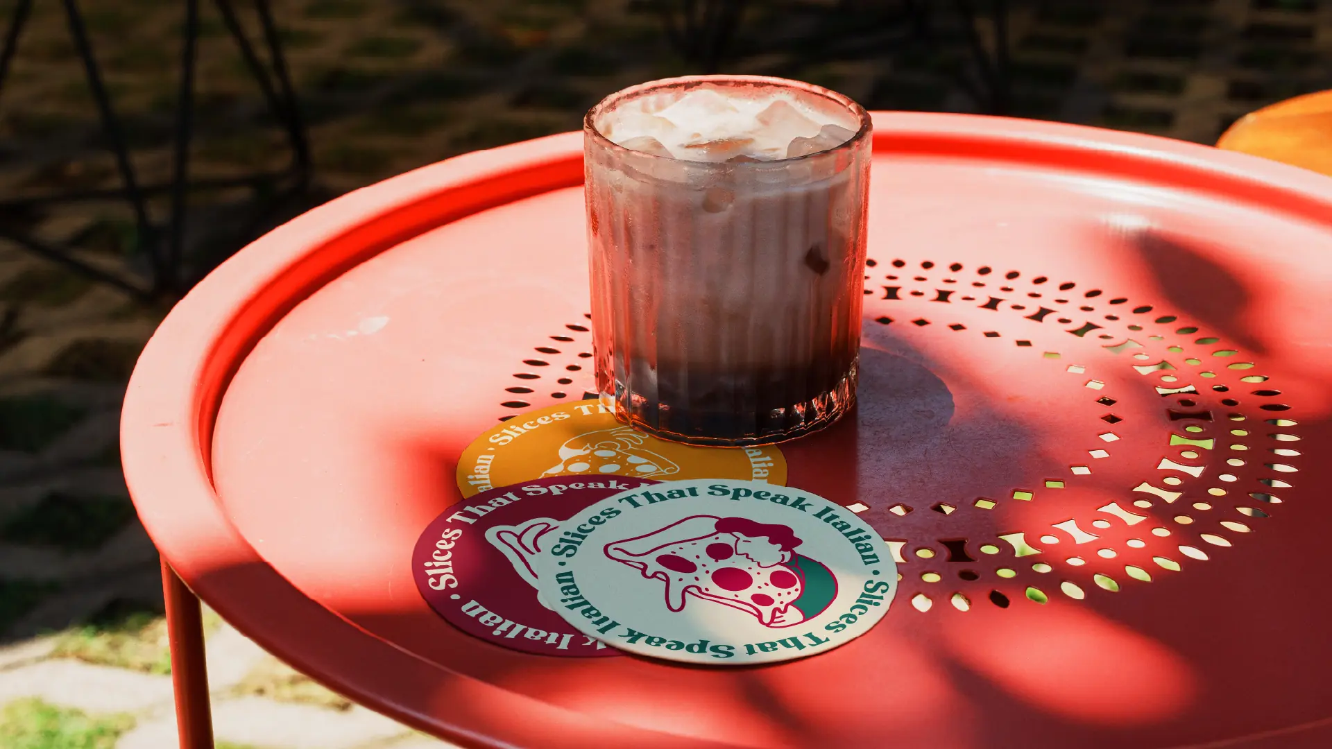 Pizza Gio coasters and sticker set on a cafe table